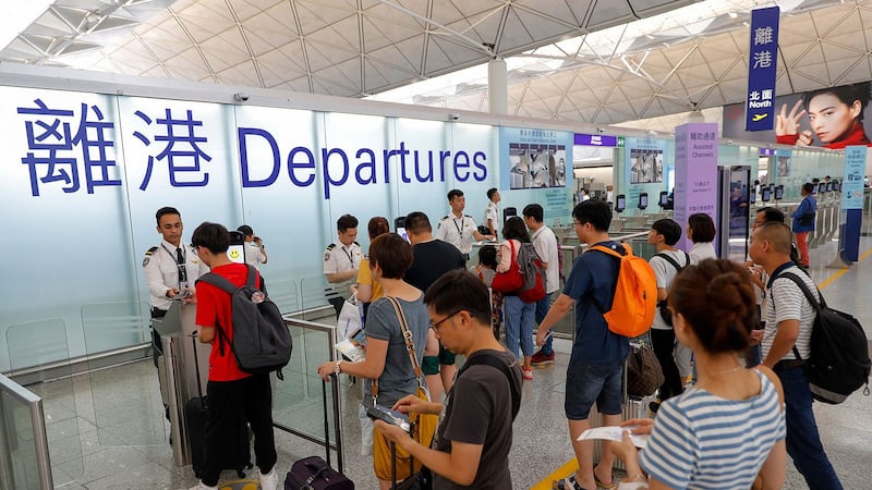 在中、港边境,中国海关近日大规模截查香港旅客,更强制翻查他们手机内的私资讯。图为2019年8月14日,旅客在香港机场登机口办理登机手续。(美联社)