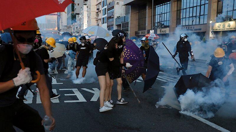 2019年7月28日,游行的香港民众试图躲避警察发射的催泪弹。(美联社)