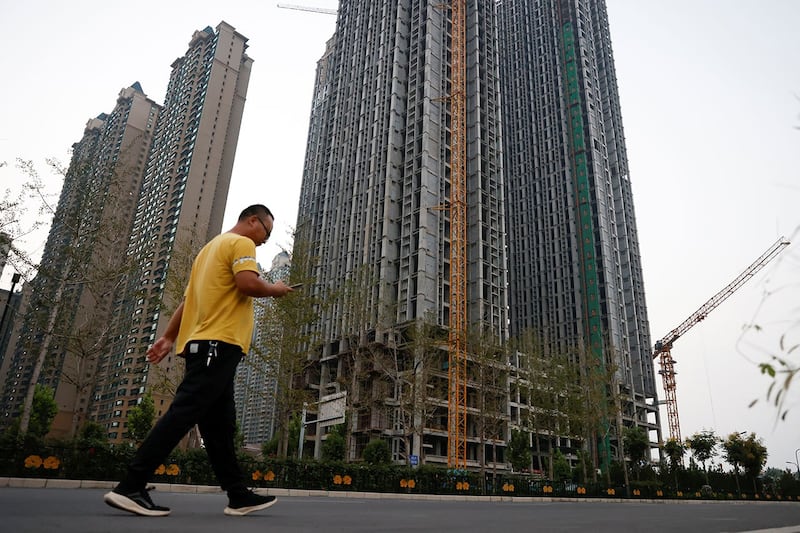 洛阳恒大集团开发的住宅区恒大绿洲,一名男子走在未完工的住宅楼前。(路透社)