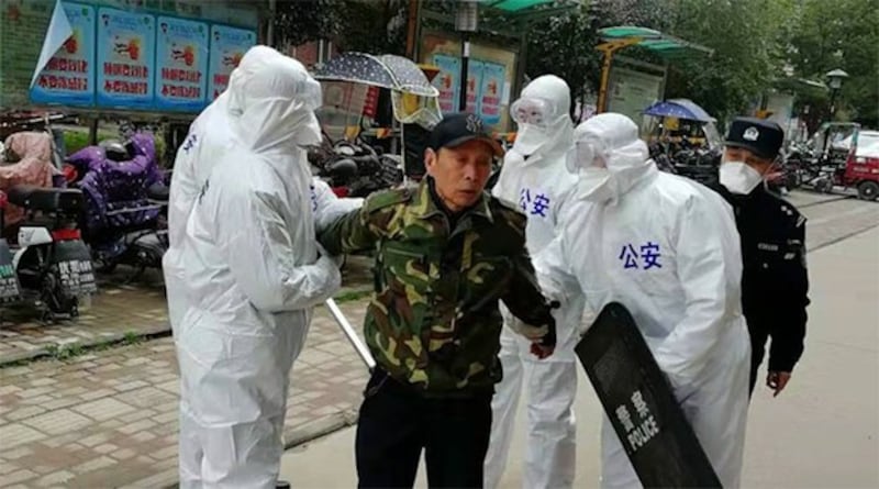 武汉颐和家园小区内,一住户未戴口罩,被公安控制。(志愿者提供/记者乔龙)