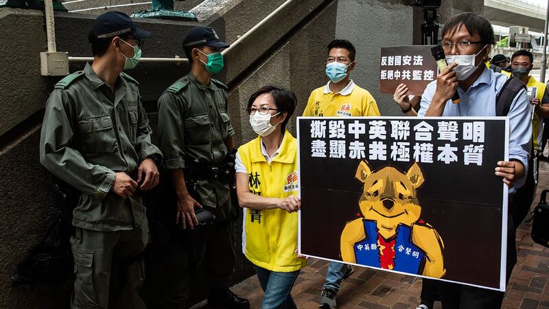 资料图片:2020 年 5 月 24 日,民主活动人士手持代表习近平的小熊维尼牌,前往香港中联办,抗议拟议新国安法。 (法新社)