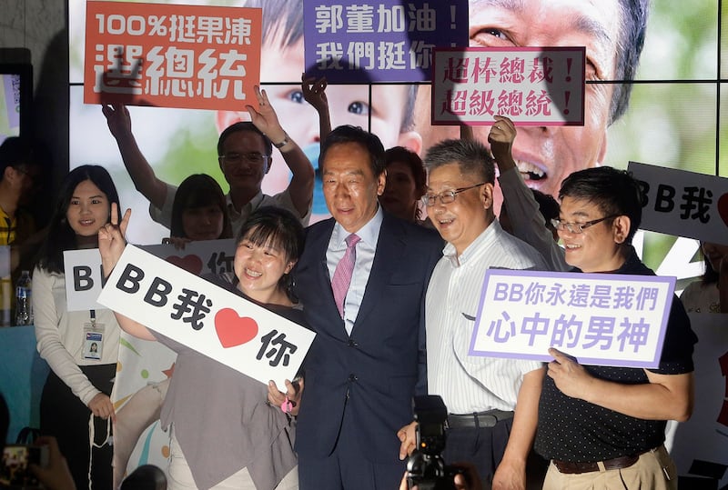资料图片:2019年6月21日,郭台铭在鸿海集团举行股东大会后,与支持者合影留念。(美联社)
