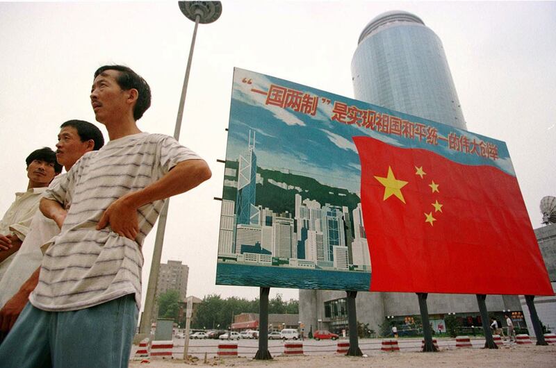 1997年7月16日,北京街头展示的香港天际线与中国国旗以及"一国两制"宣传口号。(美联社)