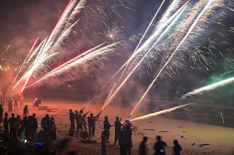 2023年元旦,中国多地民众打破中共的烟花爆竹禁燃令。图为2023年1月1日,人们在海南省三亚市后海的海滩上放烟花庆祝新年。(法新社图片)