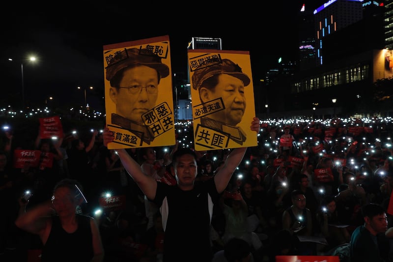 2019年6月26日,在香港集会上抗议者手持标牌“习近平与韩正画像”。(美联社)
