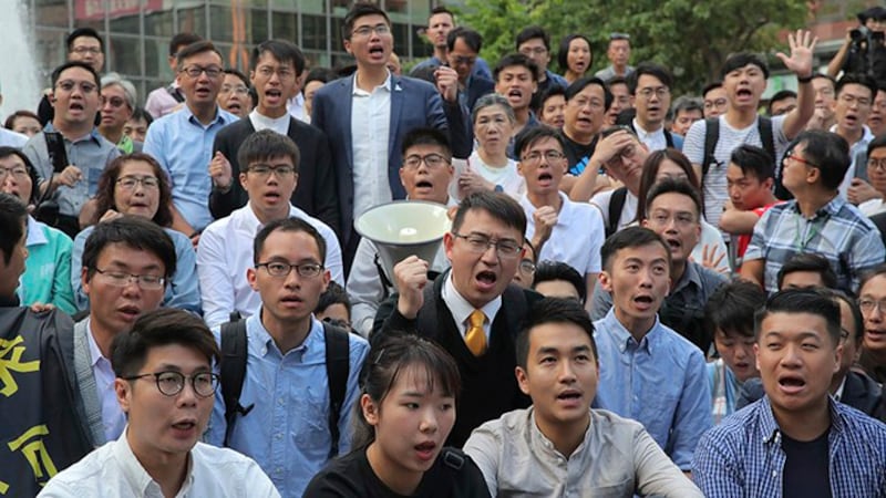 新当选的香港区议会部分民主派议员2019年11月25日聚集在香港理工大学附近(美联社)
