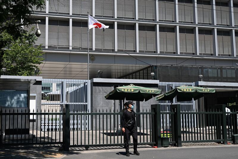 2023年8月29日,警察和保安人员站在日本驻北京大使馆门外。(法新社)