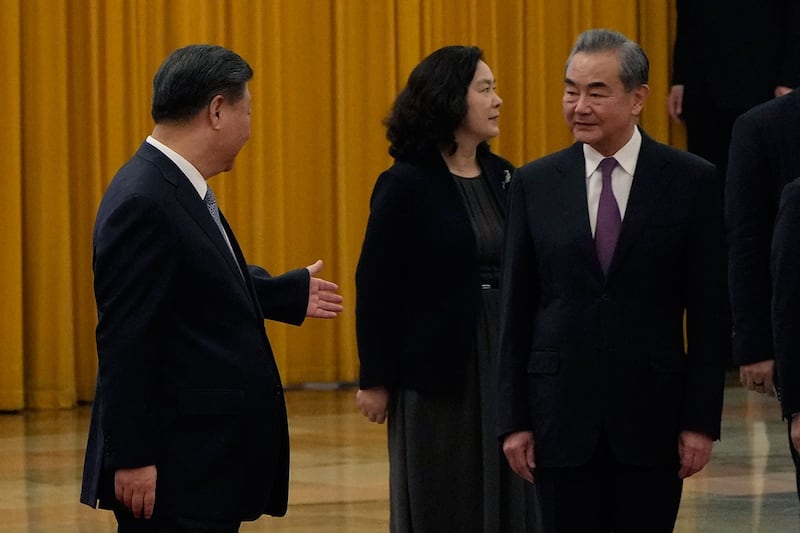 2023年7月18日,在北京人民大会堂举行的阿尔及利亚总统阿卜杜勒马吉德·特本欢迎仪式上,中国国家主席习近平(左)走在国务委员王毅(右)旁边。(美联社)