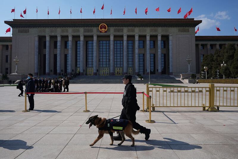 2024年3月11日,中国北京,人大会闭幕前,警察携警犬在人民大会堂外巡逻。(美联社)