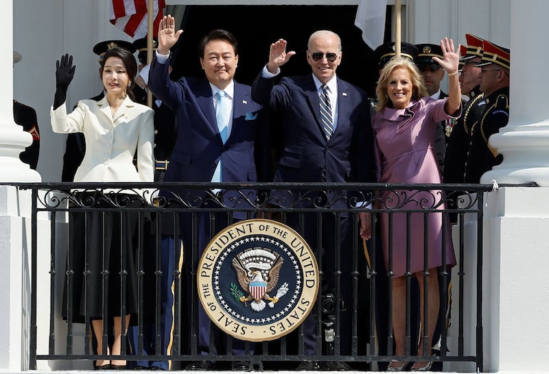 2023年4月26日,在美国华盛顿白宫,韩国总统尹锡悦(左二)夫妇和美国总统拜登(右二)夫妇站在阳台上挥手致意。(路透社)