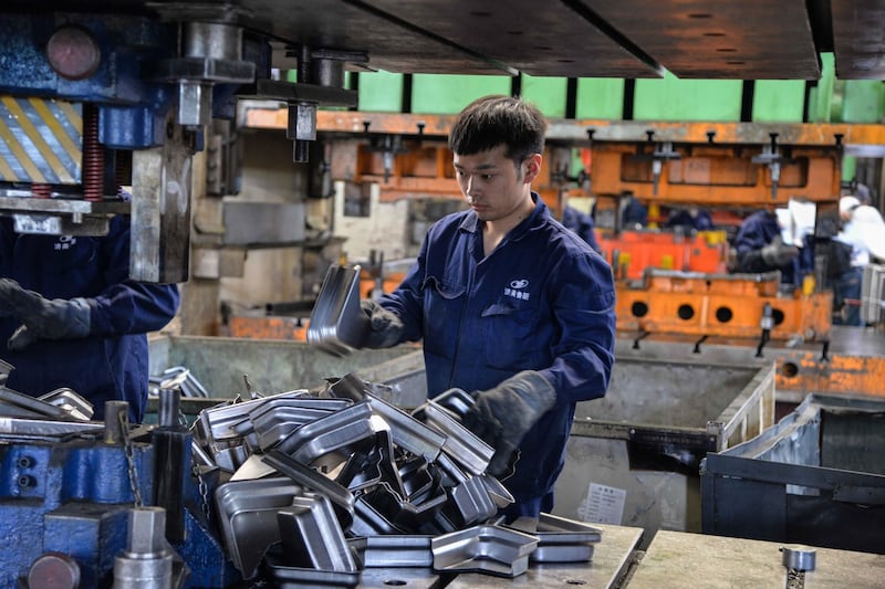 中国的制造业也在走下坡路。图为工人在山东省济南一家工厂从事汽车零部件的工作。(法新社)