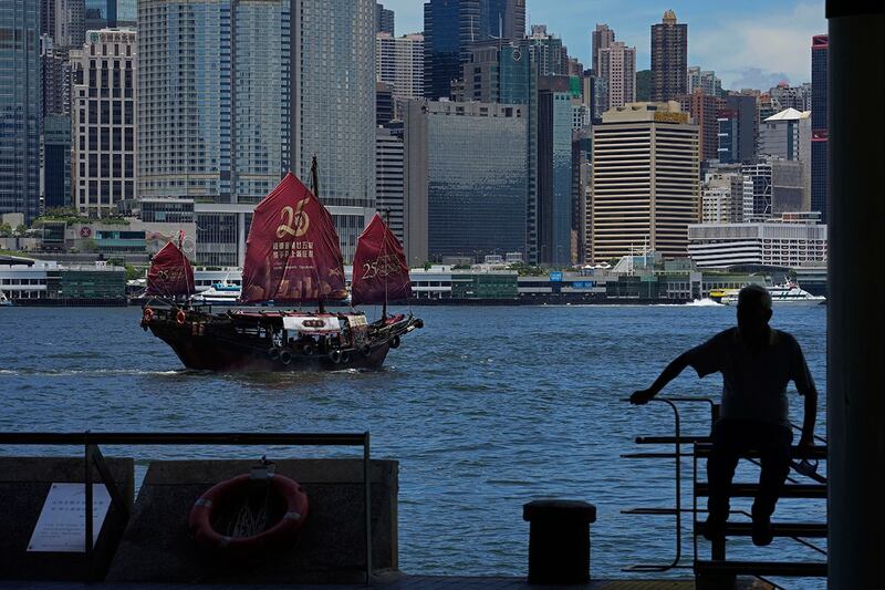2022年6月27日,一艘帆船挂上庆祝香港回归25周年横幅在维多利亚港航行。(美联社图片)