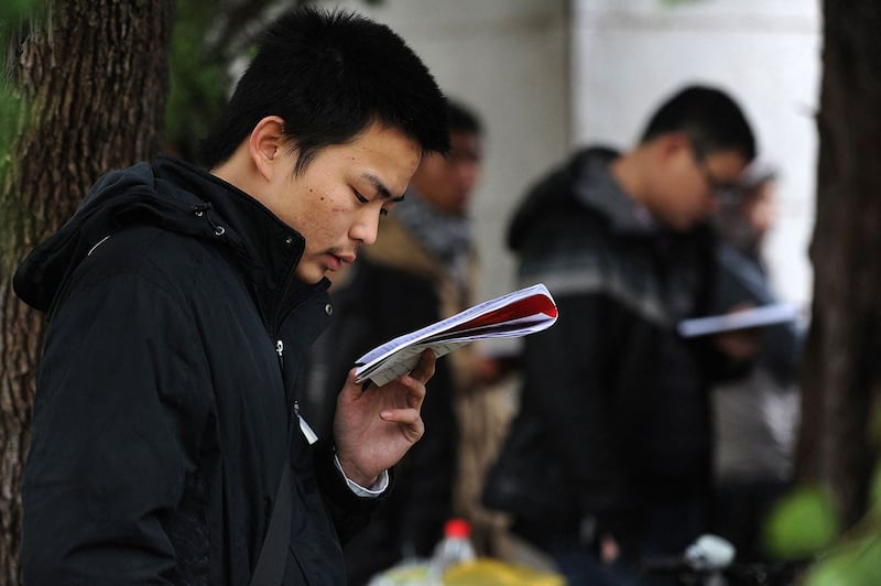 2012年11月25日,安徽合肥考生在等待参加国家公务员考试前复习。(法新社)