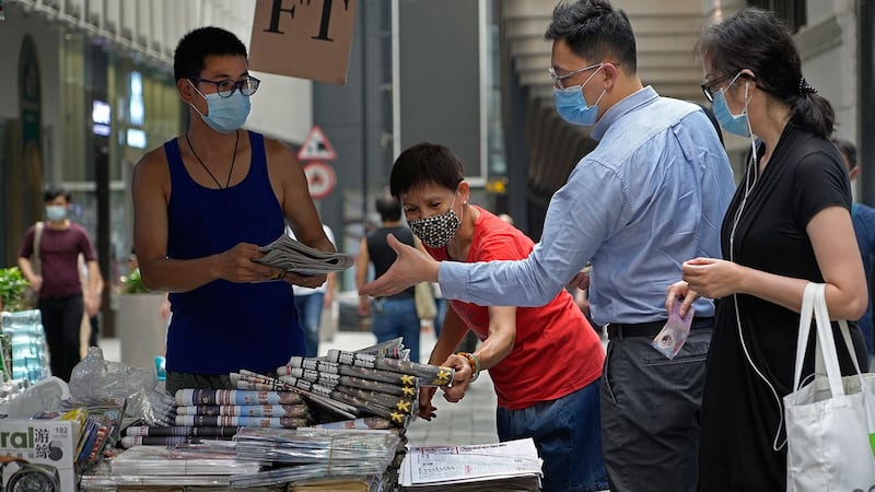 2021 年 6 月 18 日,人们在香港市中心的街道上购买 《苹果日报》。 (美联社)