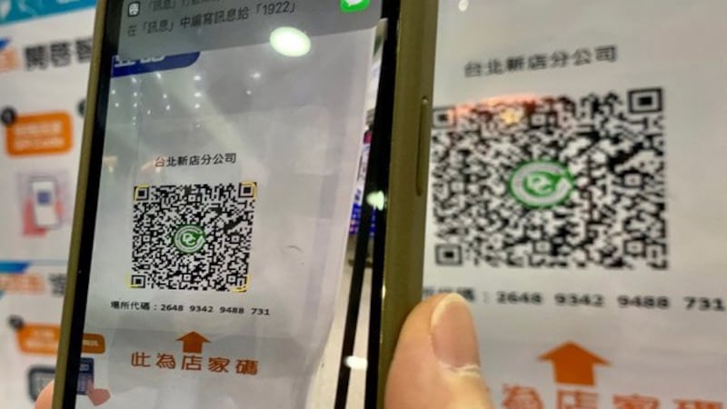台湾民众进入商店必须扫码登记实名制。(法新社)