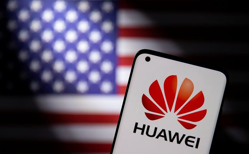 华为标志的智能手机出现在美国国旗前(路透社)