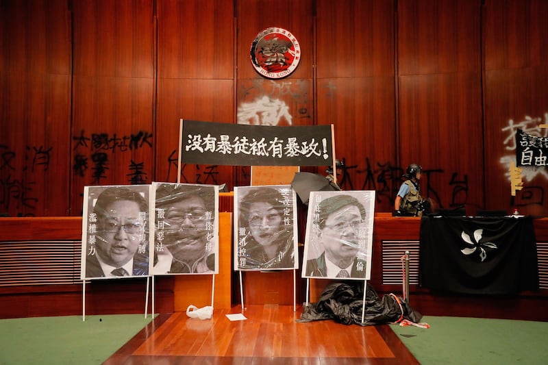 2019年7月1日,逾百示威者一度占领立法会。图为7月2日立法会议厅摆放标语牌“没有暴徒只有暴政!”,和被污损的肖像。(美联社)