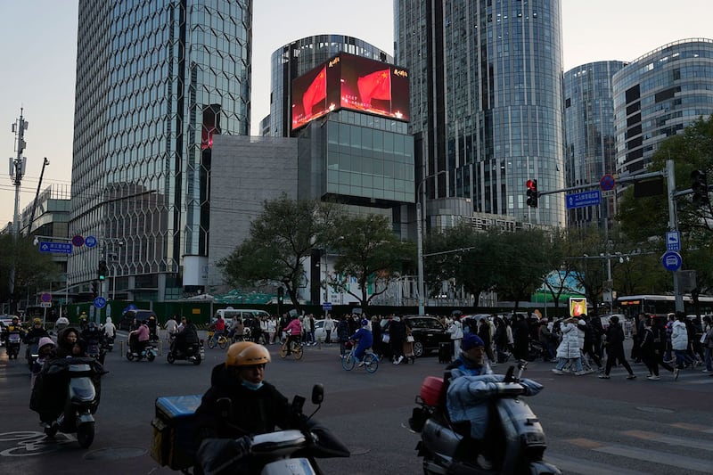 2023年11月18日,北京零售区附近,屏幕上显示着中国国旗。(美联社图片)