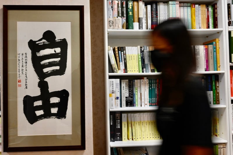 资料图:35 岁的香港护士、曾在 2019 年参加香港反送中抗议活动,走过铜锣湾书局书店展示“自由”的书法。(法新社)