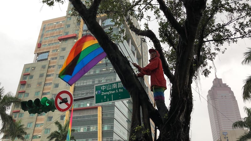 游行现场祁家威总会寻求制高点挥舞彩虹旗。(记者夏小华摄)