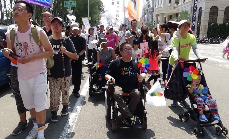 台湾第一个残障同志团体“残酷儿”团长Vincent十多年来,总是推着他的“烽火轮”,走在游行最前线。(记者夏小华摄)