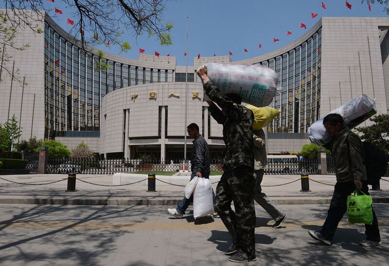有学者表示,政府过紧日子,老百姓的日子将更加艰难。图为农民工经过中国人民银行。(法新社)